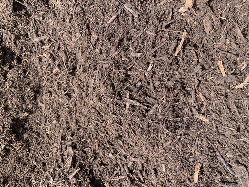 Dark double-grind hardwood mulch pile at a Burnet bulk mulch yard