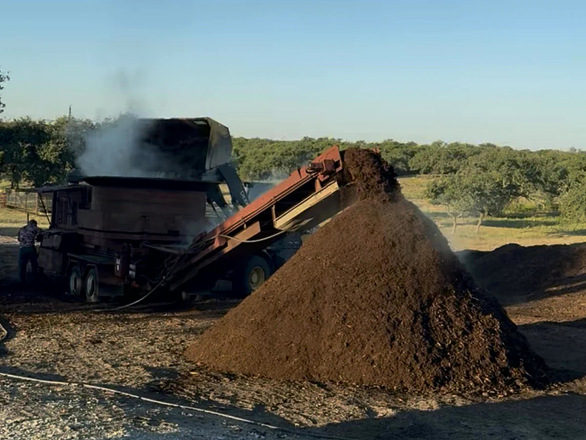 Tub grinder conveyor making a mulch pile at Burnet Brush Depot
